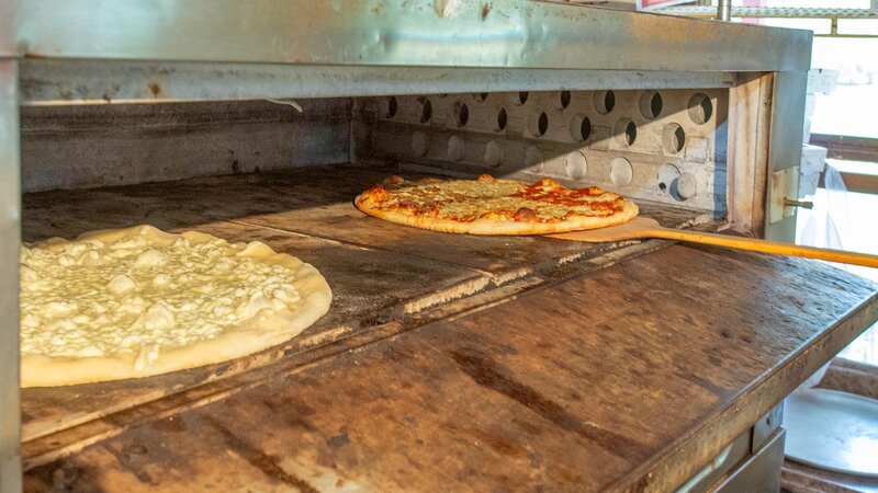 Two pizzas inside of an oven